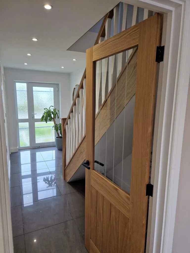 Glazed oak door beside an oak staircase