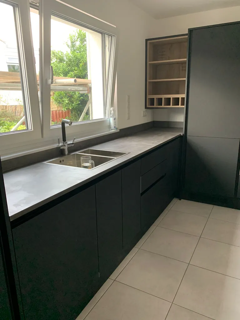 Matt black kitchen run with the sink under the window