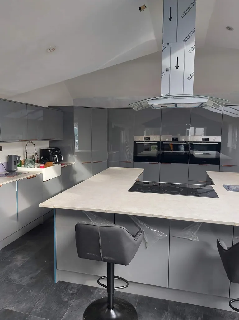 Grey gloss kitchen with an island hob and ceiling extractor